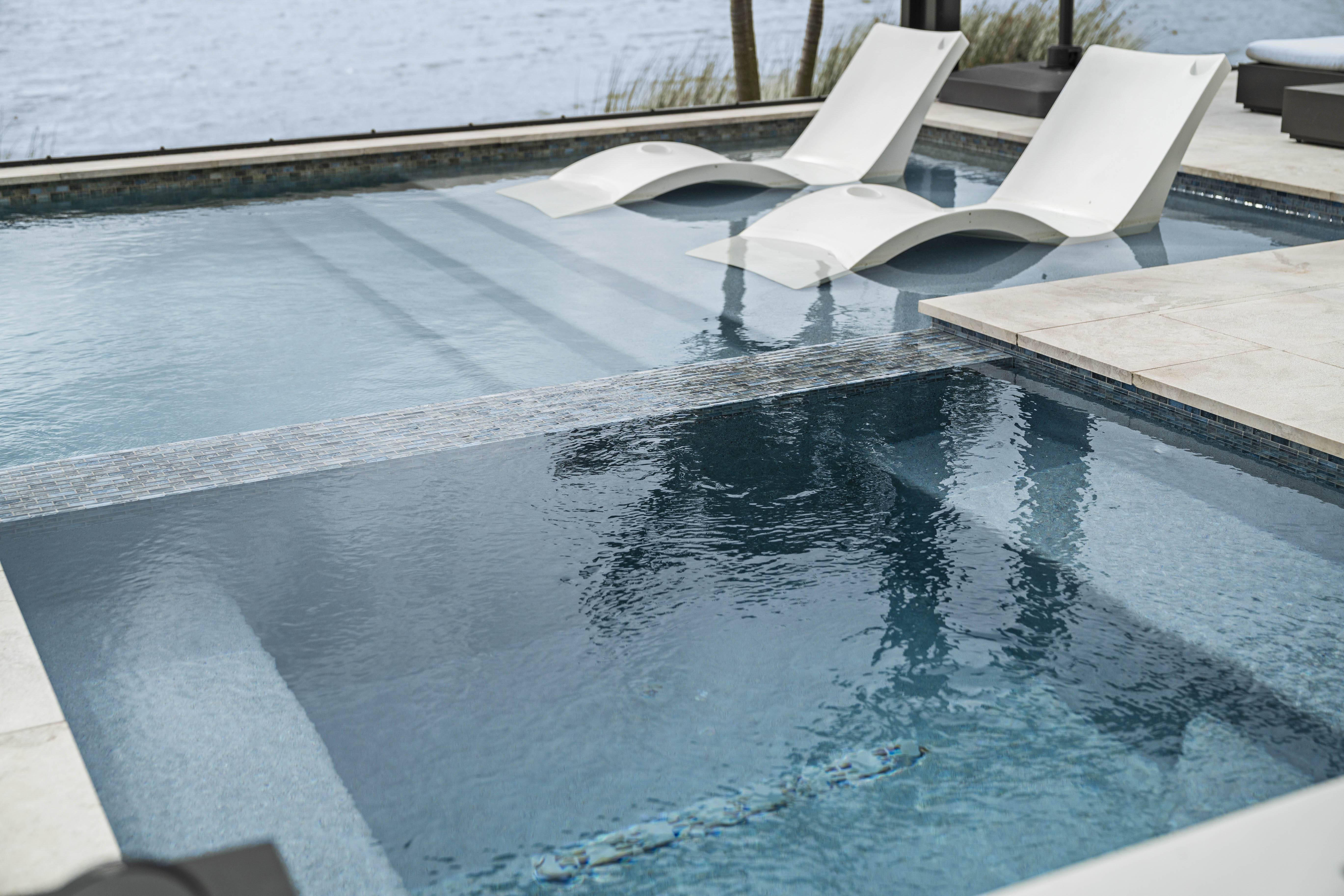 Beach entry zero-edge gradual pool entry with natural stone surrounding
