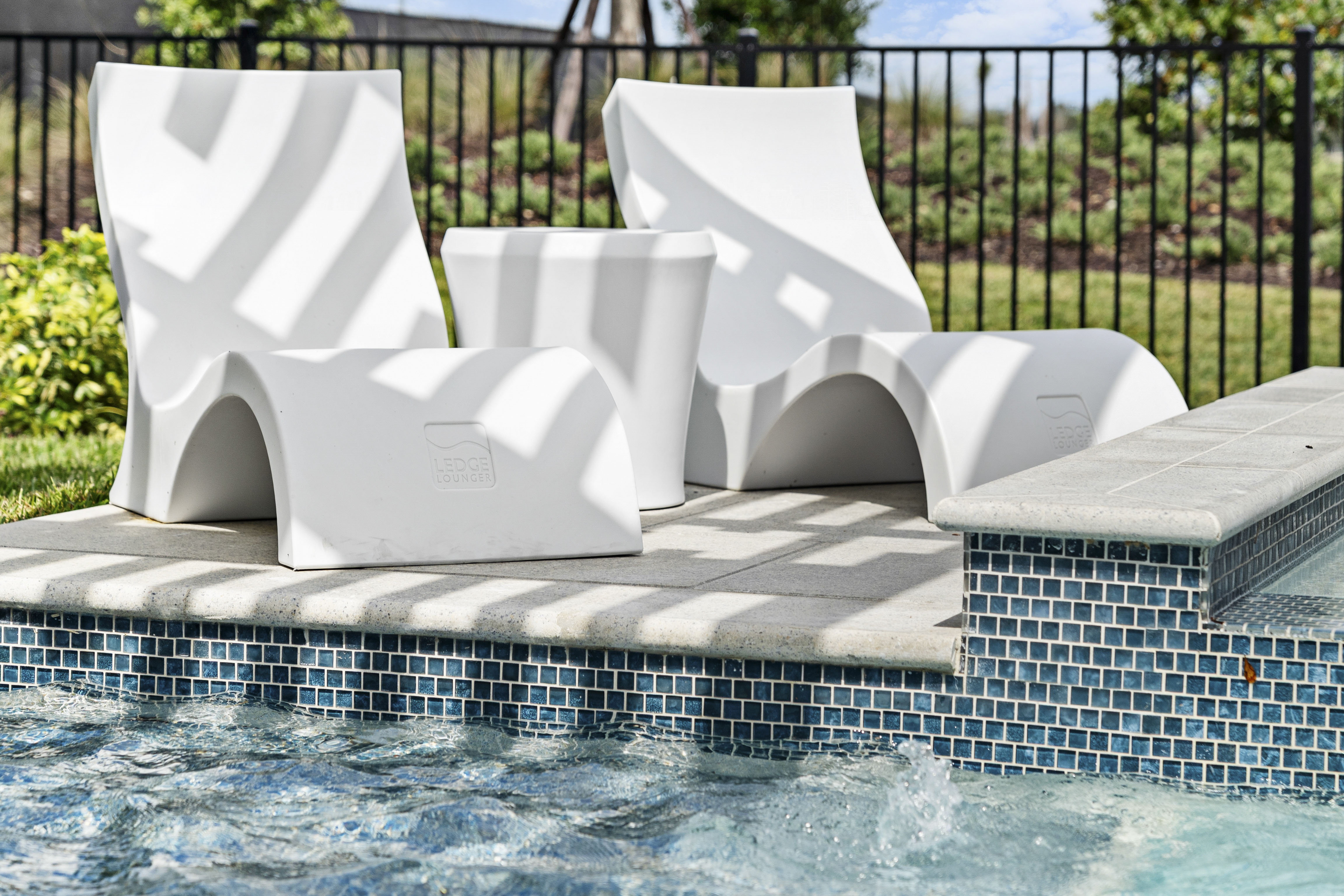 Sun shelf tanning ledge at golden hour with lounge chairs in shallow water