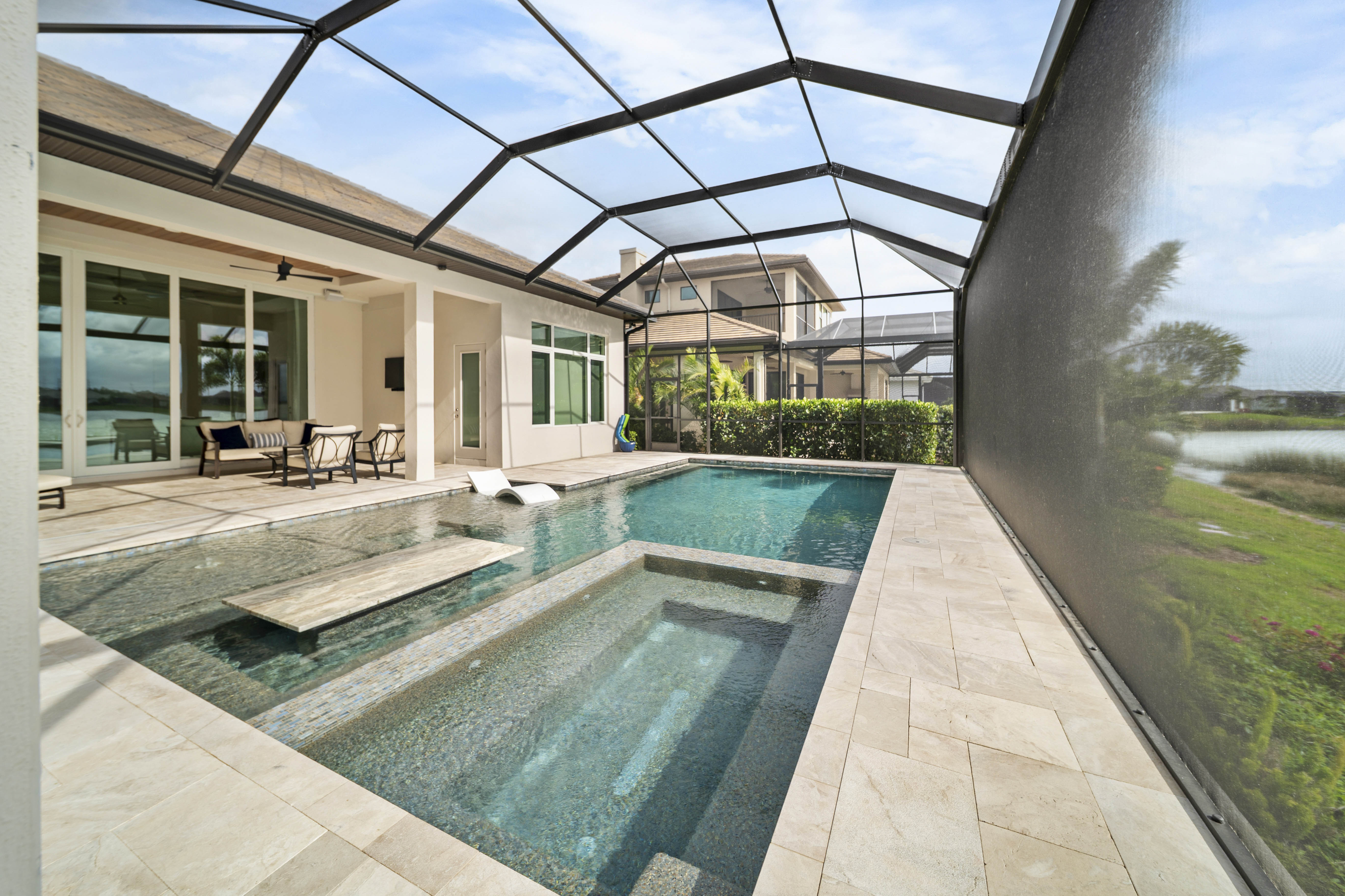 Custom pool by Swim Inc. in Osprey, FL - architecturally refined residential pool with premium hardscape at twilight