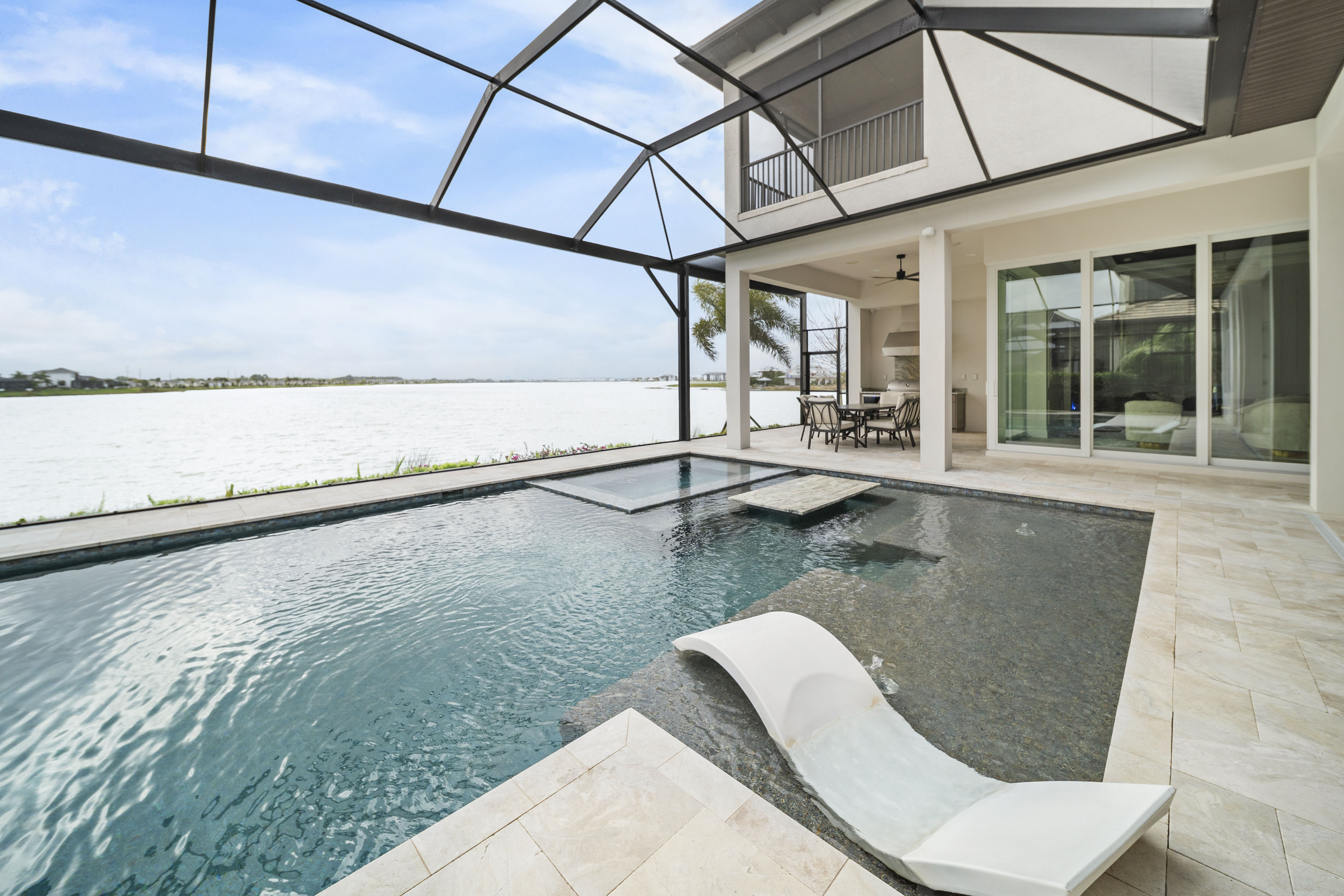 Completed luxury custom pool at twilight with LED lighting, spa, and lush landscaping