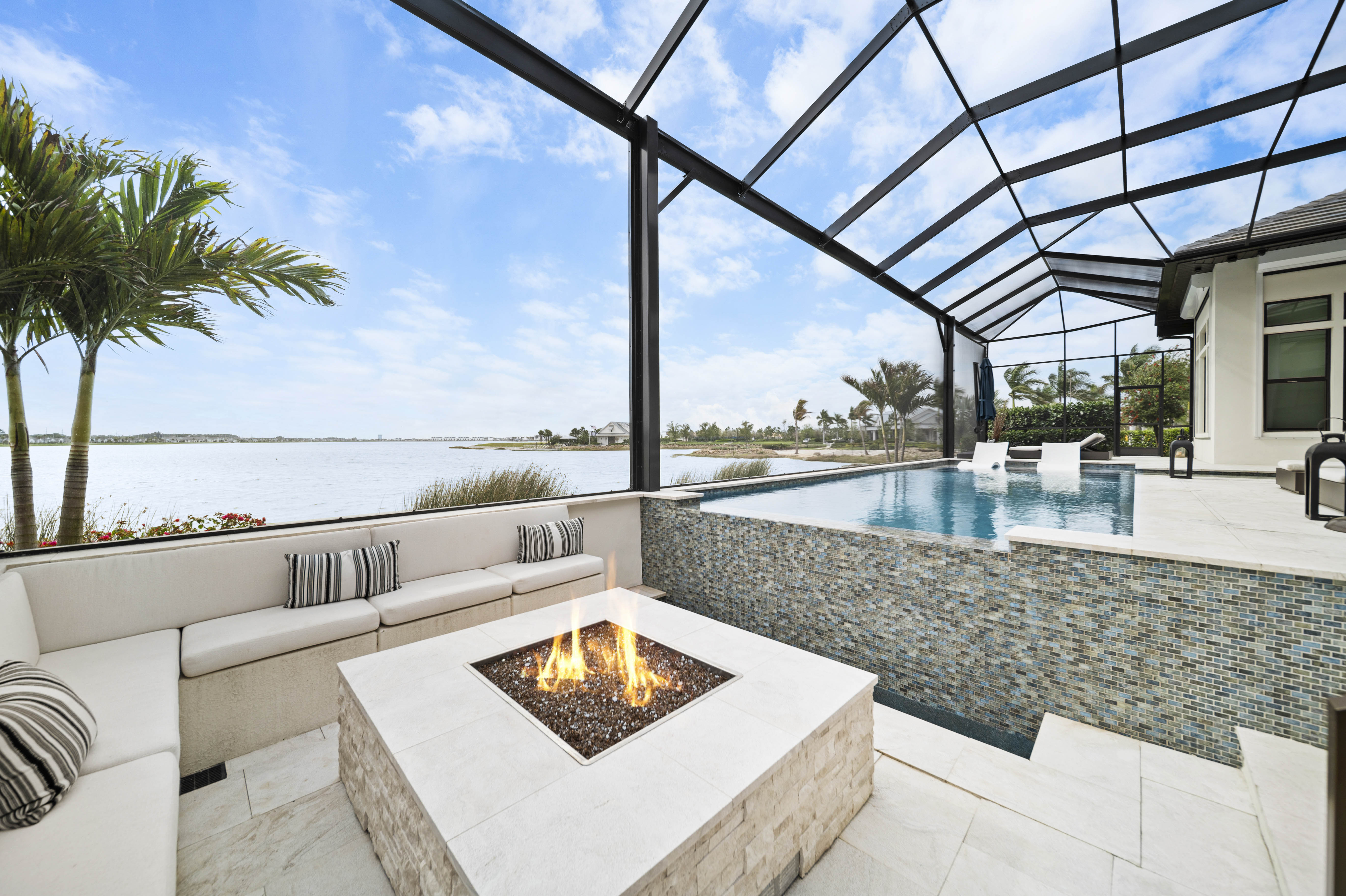 Sunken fire pit and seating area beside the vanishing edge pool at dusk, Lakewood Ranch FL, Swim Inc.