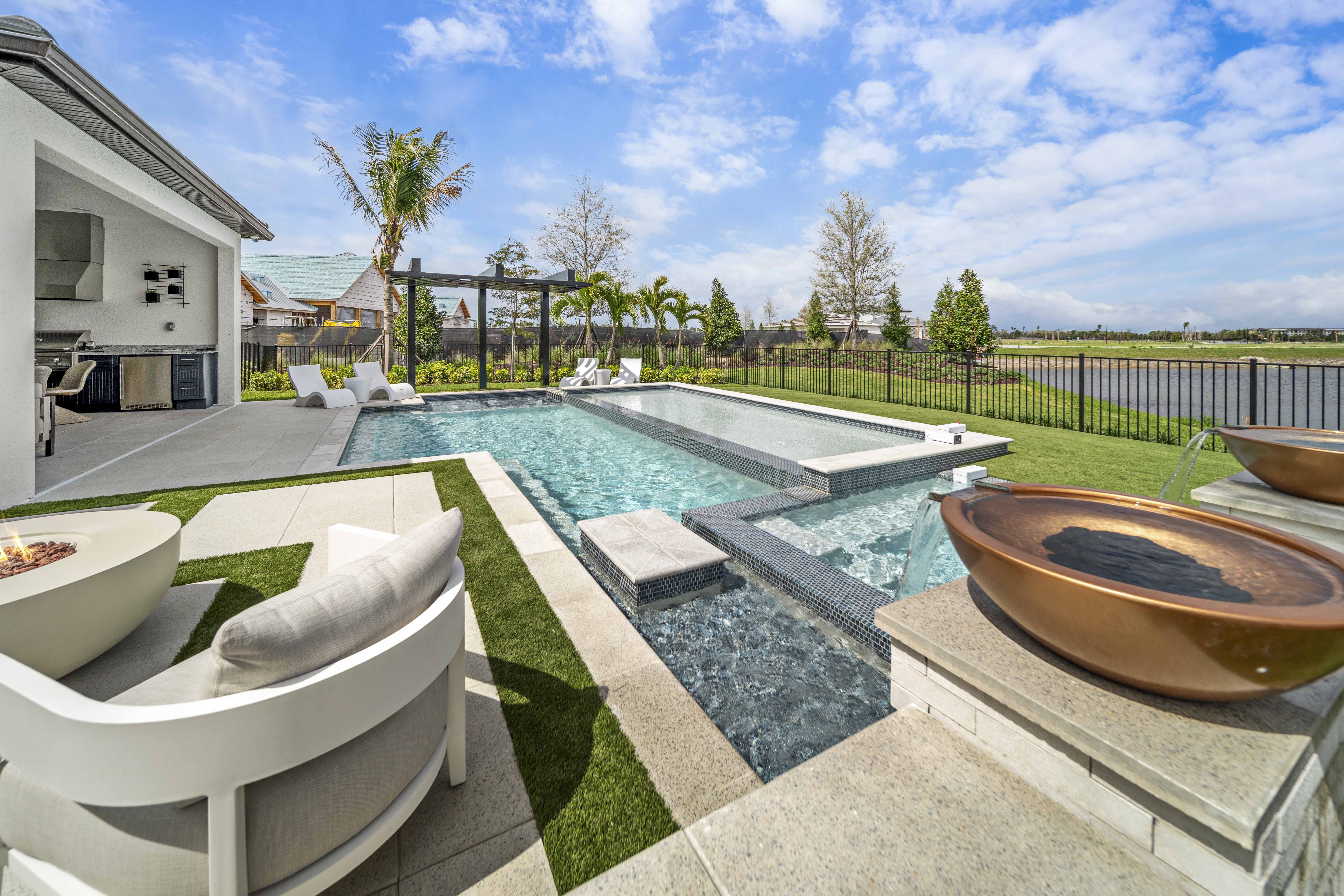 Golden hour panoramic of geometric pool with copper accents and astroturf lawn in Venice, FL, Swim Inc.