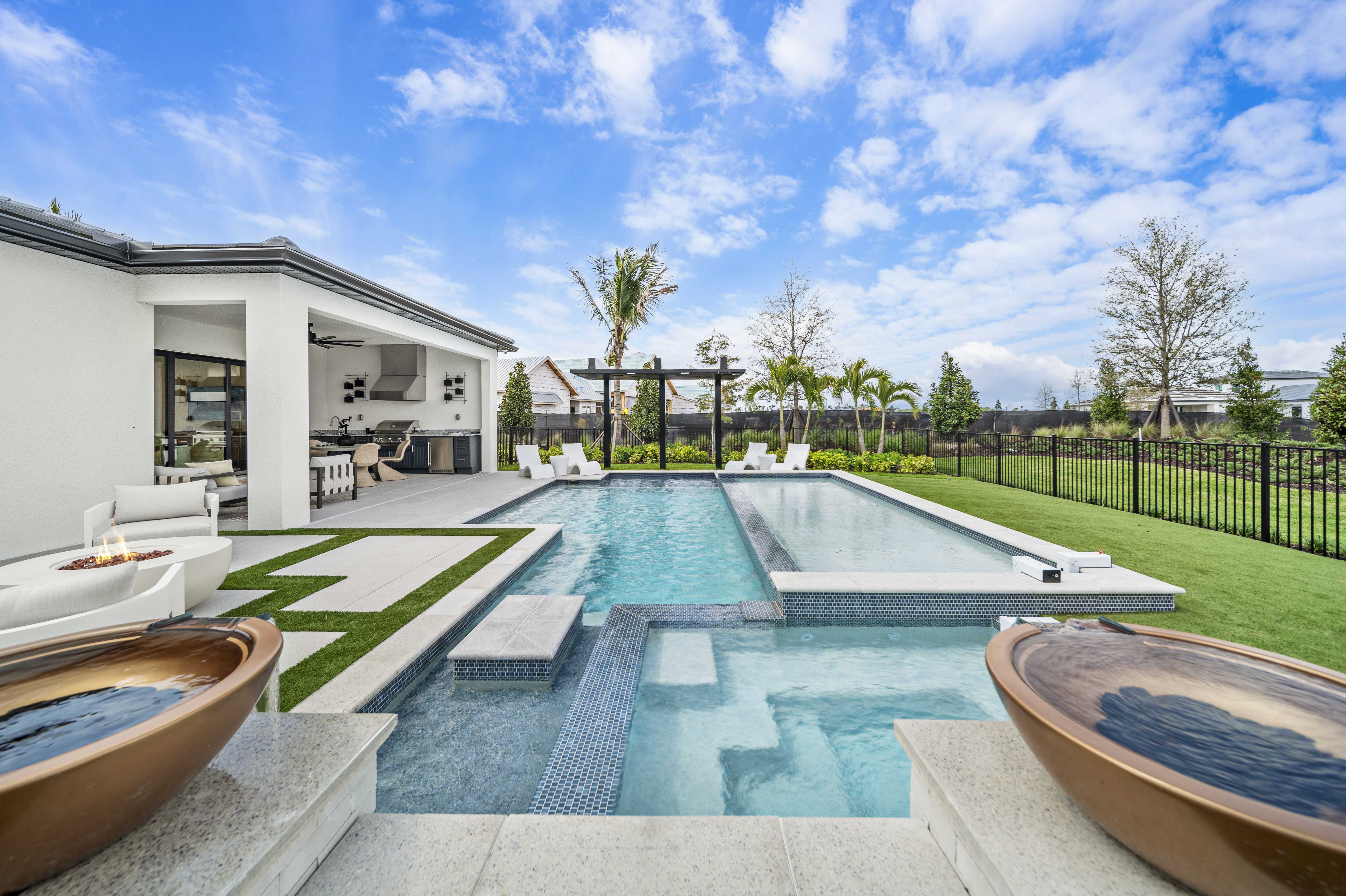 Geometric modern pool with raised sun shelf, spillover spa, and water bowls in Venice, FL by Swim Inc.