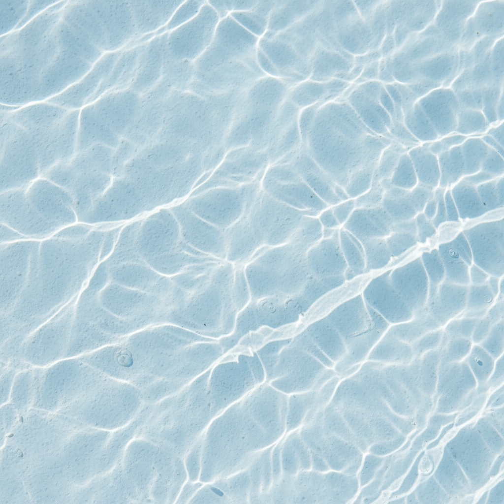 Plaster pool interior close-up, clean bright white finish in clear water