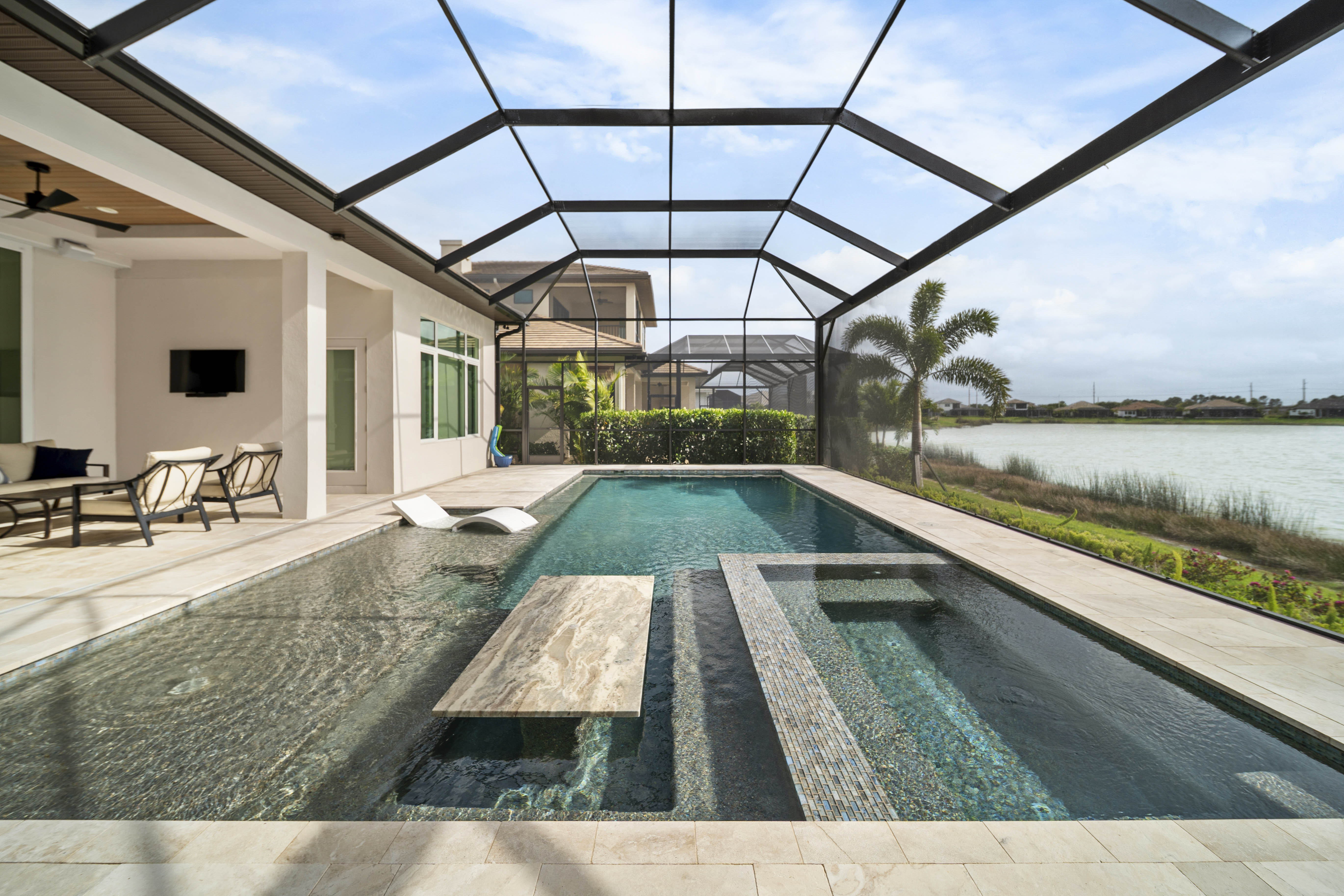The Joplings' completed pool in Sarasota with classic beach entry design and lush landscaping at twilight